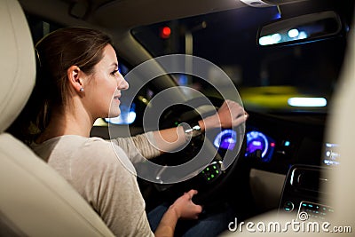 Pretty, young woman driving her modern car