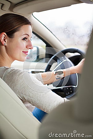 Pretty young woman driving her new car