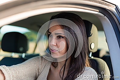 Pretty young woman driving her new car