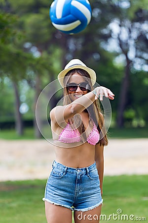 Pretty young woman playing with a ball in the city park - Sunset