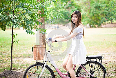 Pretty young woman relaxing with bike in a park