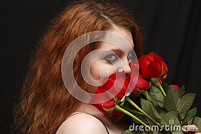 Pretty young woman smelling roses