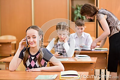 Primary school pupil using cell phone at lesson