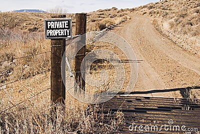 Private property sign and cattle guard along road