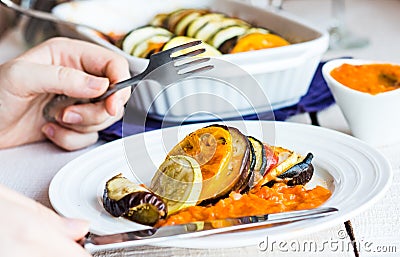 Processes food vegetable ratatouille with a fork and knife, hand