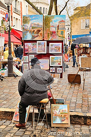 Public painter with his paintings in Place du Tertre square in Paris XVIIIe arrondissement (Montmartre)