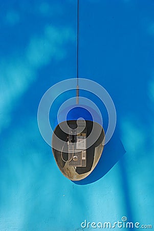 Public Phone on Blue Wall Background