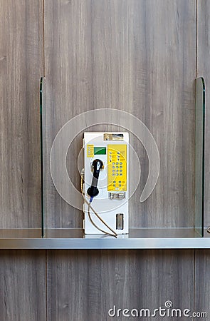 Public telephone coin on wooden wall