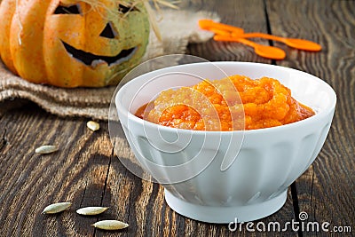 Pumpkin porridge on a background of funny Halloween pumpkin