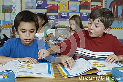 Pupils in classroom reading textbooks