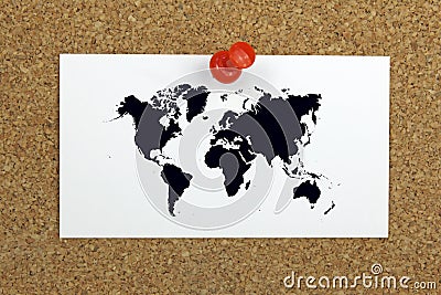 Push pin holding card with world map on a cork board