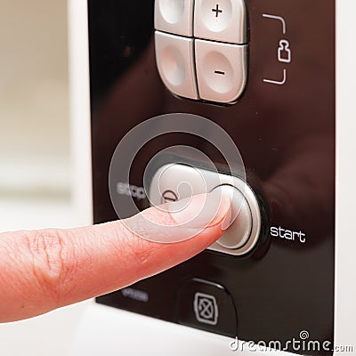 Pushing start button on the microwave oven