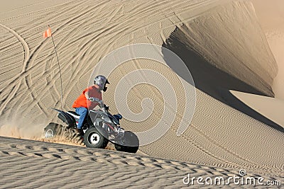 Quad rider in sand dunes bowl
