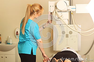 Radiologic technician and female patient lying on a CT Scan bed