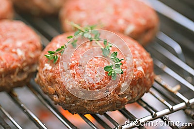 Raw burgers on bbq barbecue grill with fire