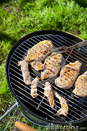 Raw chicken fillet breast cooking on barbeque grid