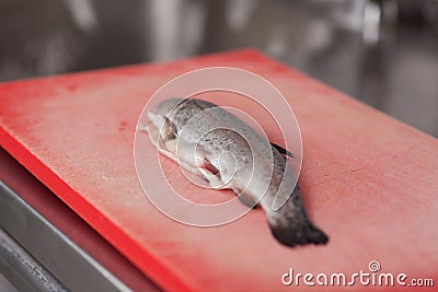 Raw Fish On Chopping Board At Commercial Kitchen