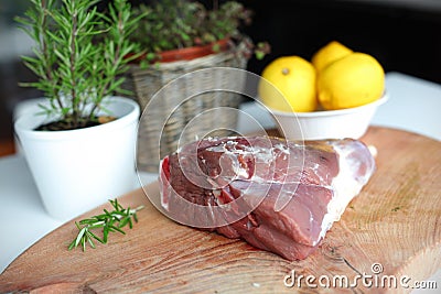 Raw lamb leg meat on the wooden cutting board