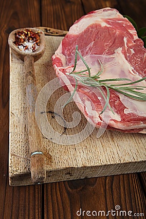 Raw shoulder lamb on wooden board and table