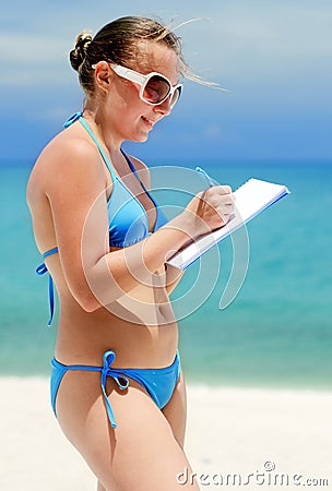 Young woman with notebook on a beach