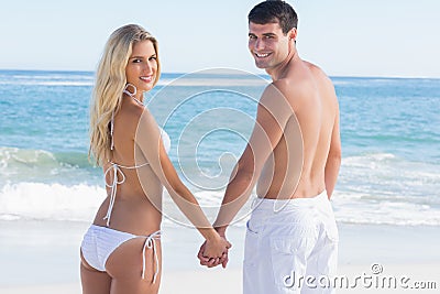 Rear view of couple holding hands looking at camera