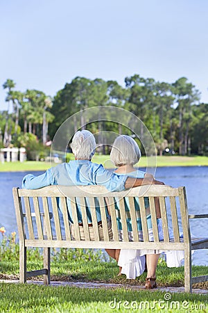 Rear View Senior Couple Sitting On Park Bench