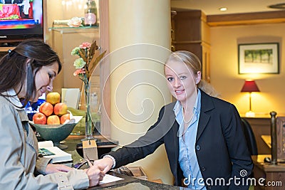 Receptionist helping a hotel guest check in