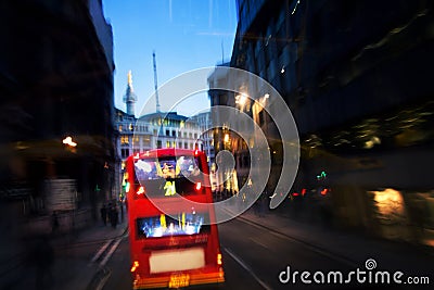 Red bus on street by night in London