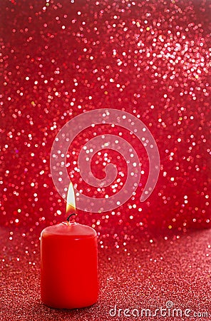 Red candle. Red glittering christmas lights. Blurred abstract ba