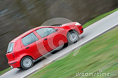 Red car speeding in panned motion