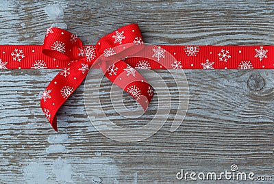 Red christmas ribbon bow on wooden board