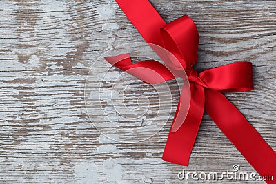 Red christmas ribbon bow on wooden board