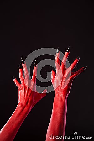 Red devil hands with sharp black nails, real body-art