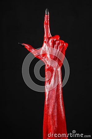 Red Devil s hands with black nails, red hands of Satan, Halloween theme, on a black background, isolated