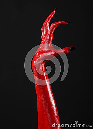 Red Devil s hands with black nails, red hands of Satan, Halloween theme, on a black background, isolated