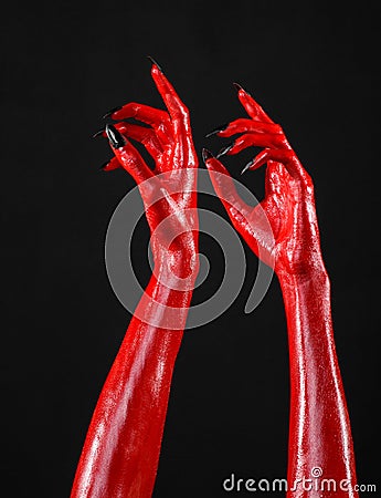 Red Devil s hands with black nails, red hands of Satan, Halloween theme, on a black background, isolated