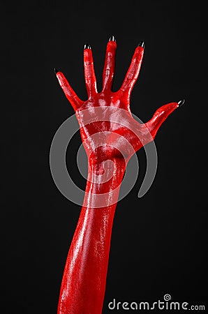 Red Devil s hands with black nails, red hands of Satan, Halloween theme, on a black background, isolated