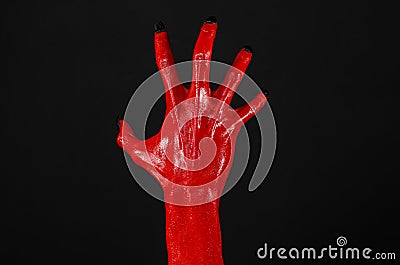 Red Devil s hands with black nails, red hands of Satan, Halloween theme, on a black background, isolated