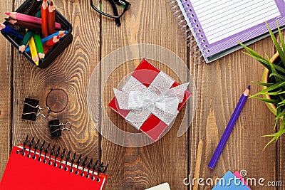 Red gift box and office supplies over office table