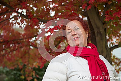 Red Hair Senior Lady Under the Tree Looking at you Happily