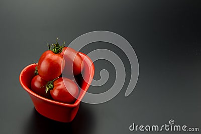 Red heart-shaped dish and small tomatoes