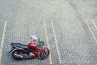 Red Motorcycle on empty car parking pavement