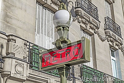 Red Paris Metro subway sign with street lamp