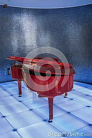 Red piano on blue club scene.