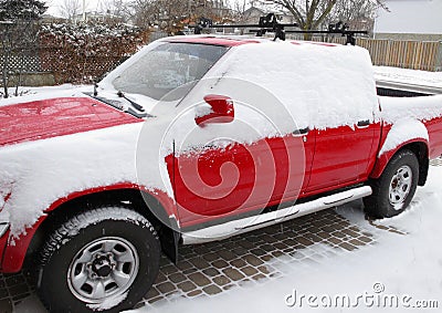 Red pickup with snow in driveway