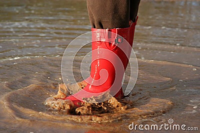 Red rain boots in puddle