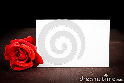 Red rose and blank gift card for text on old wood background