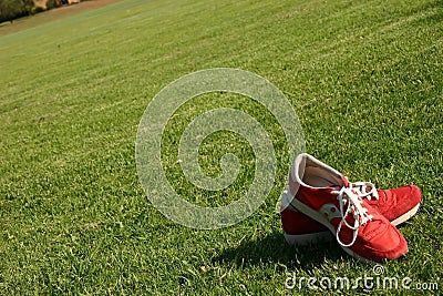 Red running shoes on a sports field