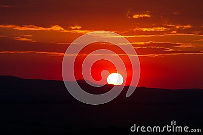 The red sunset sky with the sun and clouds