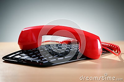 Red telephone receiver on keyboard